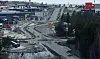 Veier, kryss og veiarbeid ved et industrielt havneområde med biler og lasteutstyr.