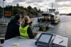 To personer sitter ved et bord og ser mot en bilferje som legger til ved kaia.