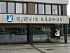 Fasaden til Gjøvik rådhus med inngang, vinduer og skilt.