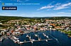 Flyfoto av Lillesand med havn, seilbåter, boliger og kystlandskap.