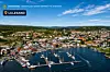 Flyfoto av Lillesand med havn, seilbåter, boliger og kystlandskap.