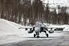 Svensk Saab JAS 39 Gripen taxer mot kamera på en snødekt rullebane.