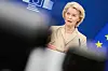 Ursula von der Leyen taler foran EU-flagg og en blå bakgrunn.