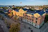 Rådhuset sett ovenfra om høsten, omgitt av bygater, trær og bybebyggelse.